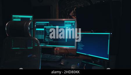 acker workplace has three monitors, the room is dark, there are no people Stock Photo