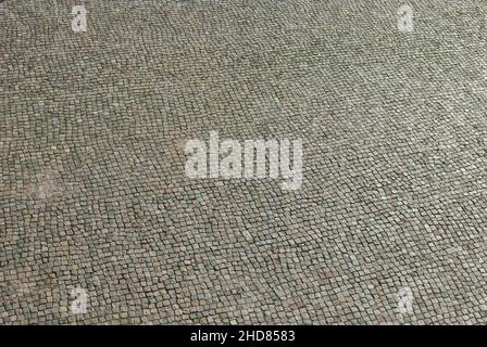 Cobblestone paved road surface as grey stone background Stock Photo
