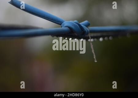 Water droplets hanging on the wire and reflecting its background after heavy rainfall at Kathmandu, Nepal. Stock Photo