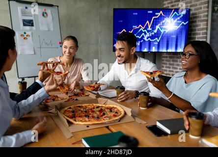 Pizza Delivery. Diverse Multiethnic Colleagues Eating Lunch Together During Break In Office Stock Photo
