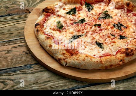 Whole neapolitan pizza served on wooden board. Stock Photo