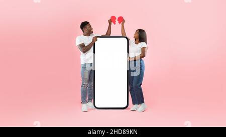 Black couple connecting two halves of broken heart, mockup screen Stock Photo
