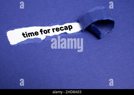 The text TIME FOR RECAP appearing on whitepaper behind torn blue paper. Stock Photo