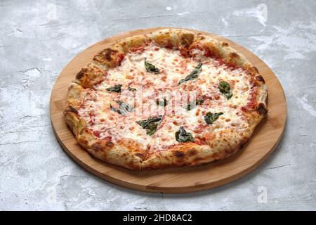 Whole neapolitan pizza served on wooden board. Stock Photo