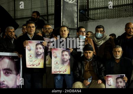 Gaza City, Gaza Strip, Palestine. 3rd Jan, 2022. Gaza, Palestine. 04 January 2022. Supporters of the Palestinian Islamic Jihad Movement in Palestine hold a protest in solidarity with hunger-striking Palestinian administrative detainee Hisham Abu Hawash in Gaza City. Hisham Abu Hawash has been on hunger strike for more than 140 days inside Israeli prisons in protest for being held under the Israel's policy of administrative detention, which means that he has not been charged with a crime. The International Committee of the Red Cross and prison groups have warned that Hawash' health condit Stock Photo