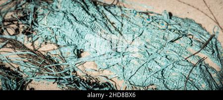 BANNER abstract beauty background. Copy space soft bag cloth rag fabric flap texture surface material on sand ground. Turquoise light blue colour Stock Photo