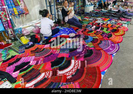 Colourful local style skirts and fabrics displayed in the walking street night market in central Luang Prabang, northern Laos, south-east Asia Stock Photo