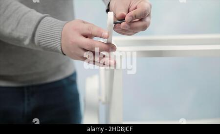 Man collects furniture in a workshop. Stock. Bonding and assembly of furniture on the wooden pins Stock Photo