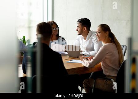 Corporate Lifestyle. Group Of Multiethnic Coworkers Brainstorming On Business Project Stock Photo