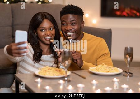 African Spouses Using Smartphone Making Selfie Celebrating Valentine At Home Stock Photo