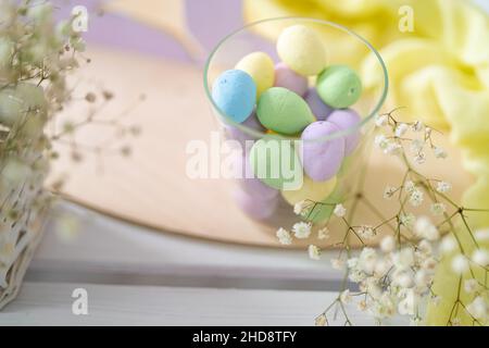 Flower composition with easter colorful dyed eggs in a glass container. Easter composition. Stock Photo