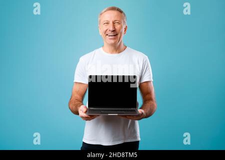 Happy mature man showing black empty pc screen Stock Photo