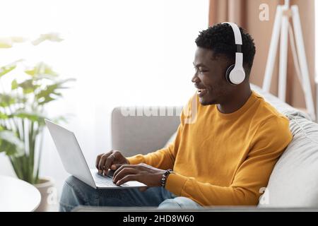 Handsome black guy having webinar, using laptop at home Stock Photo
