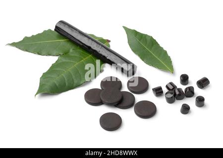 Heap of black Bay Leaf Licorice in different shape and fresh bay leaves isolated on white background Stock Photo