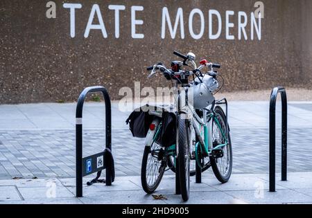 London England UK January 02 2022, Two Bicycles Parked Outside A Sign for Tate Modern Southwark London Stock Photo