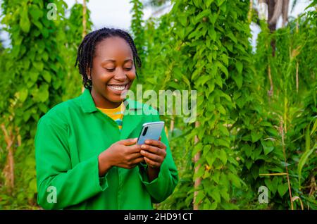 beautiful african farmer happy with the news she saw on her phone Stock Photo