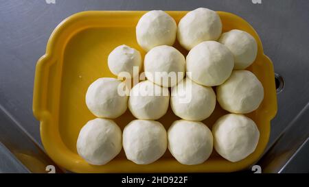 Homemade butter on a tray. Production of butter on an industrial scale. Butter in the shape of a ball. Stock Photo