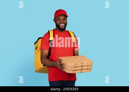 Pizza Delivery. Black Courier Man In Uniform Holding Stack Of Cardboard Boxes Stock Photo