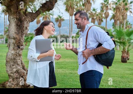 Middle aged business colleagues talking in the park Stock Photo