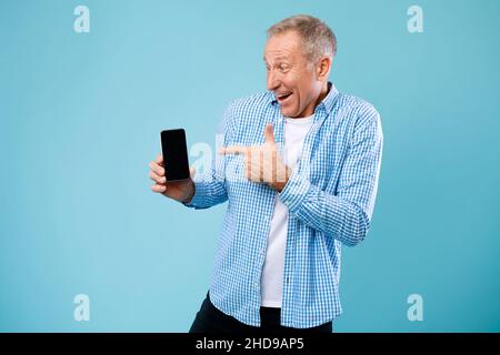 Mature man pointing finger at empty smartphone screen Stock Photo