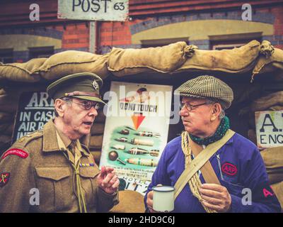 Re-enactors in 1940 wartime costumes as ARP warden (air raid precaution) and army officer, Severn Valley heritage railway 1940s WW2 summer event UK. Stock Photo