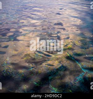 Closeup of the sea waves with the sunlight reflecting in the clear water Stock Photo