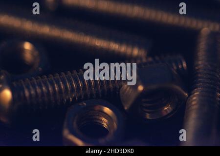 A closeup shot of many bolts and nuts under the light Stock Photo