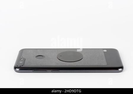 Touch screen smart phone in silicone cover. Metal plate on the back of the phone. Accessories for magnetic car phone holder. Stock Photo