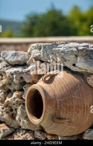 large terracotta greek urn or olive jar used as a fountain water feature decoration in a greek garden on the island of zakynthos zante. Stock Photo