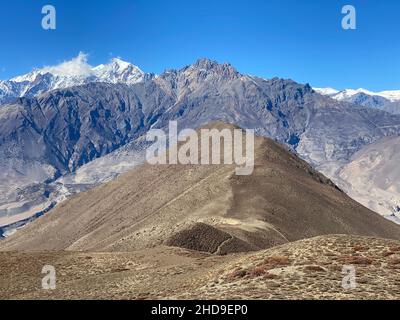Rocky mountains with peaks covered with snow under the clear blue sky on a sunny day Stock Photo