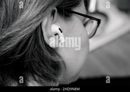 Close-up of rear woman ear with new wireless bluetooth in-ear headphones Stock Photo