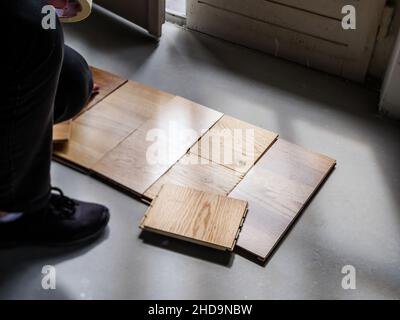 Overhead view of women choosing multiple wooden floor parquet flooring from diverse manufacturer and diverse nuances in her new house Stock Photo
