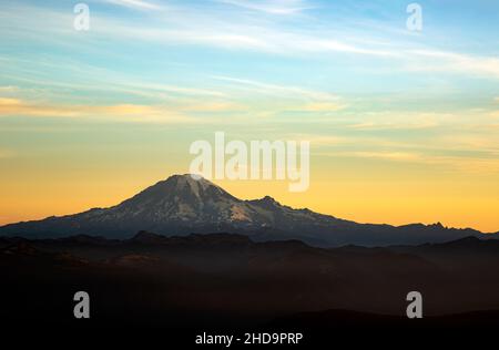 WA19992-00...WASHINGTON - Valleys and sky filled with smoke from wildfires at sunrise from Mount Adams Wilderness. Mount Rainier in the distance. Stock Photo