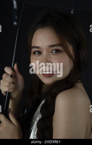 Portrait of a cheerful beautiful young woman from Vietnam with an umbrella Stock Photo