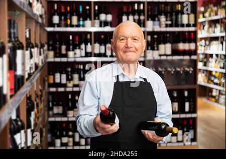 vintner offering wine in modern wineshop Stock Photo
