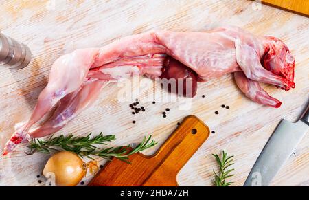 Raw skinless rabbit on wooden table Stock Photo