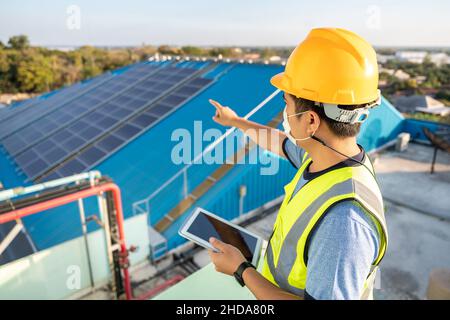 An engineer checking the operation of the system Solar power on the roof, Photovoltaic module idea for clean energy production. solar panel on roof. Stock Photo