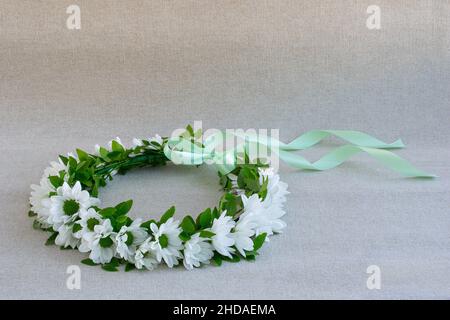 Wreath of white flowers on light linen background Stock Photo