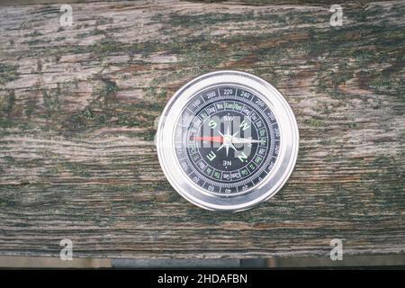 Vintage old compass on a brown wood textured background Stock Photo