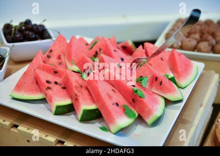 Closeup shot of sliced watermelon on a plate served on a buffet table