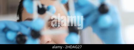 Scientist looks at model of mockup made of molecules closeup Stock Photo