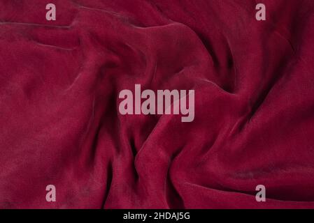 Soft smooth burgundy silk fabric background. Fabric texture. Stock Photo