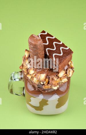 Chocolate extreme milkshake with brownie cake, chocolate paste and sweets. Crazy freakshake food trend. Copy space Stock Photo