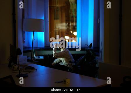 Tired programmer stay at work overtime at night before project deadline keep awake drinking coffee Stock Photo