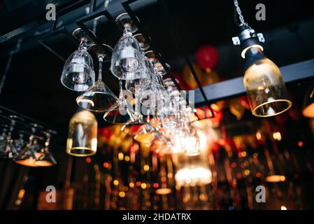 Rows of empty wine glasses on the bar counter in the restaurant or bar. Stock Photo