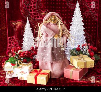 The Befana with yellow straw hair on Christmas background. Traditional witch costume for Italian Epiphany day. Stock Photo