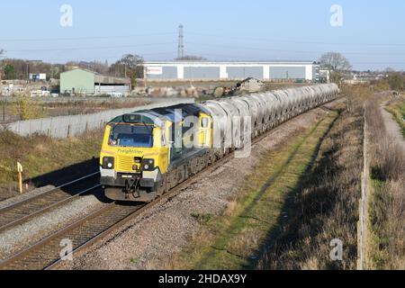 Freightliner Class 70 diesel number 70015 leading a Hope Earles Sidings to Walsall Freight Terminal train of cement hoppers in low winter sunshine Stock Photo