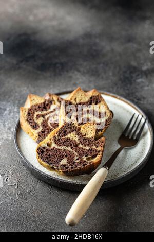 Three slices of zebra cake on a plate with the fork, copy space, isolated Stock Photo