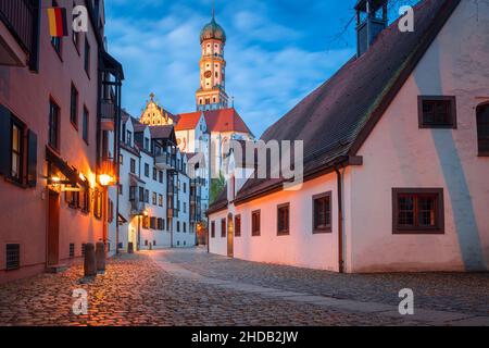 Augsburg, Germany. Cityscape image of old town street of Augsburg, Germany with the Basilica of St. Ulrich and Afra at autumn sunset. Stock Photo