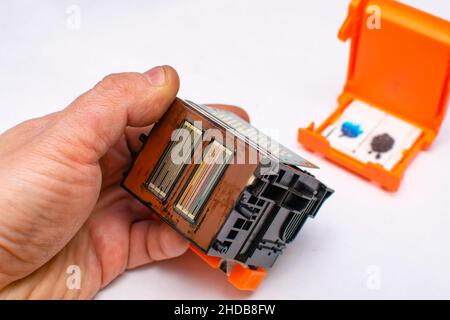 close up, faulty, dirty color ink printhead in the hand of a service center master on a clean white background Stock Photo